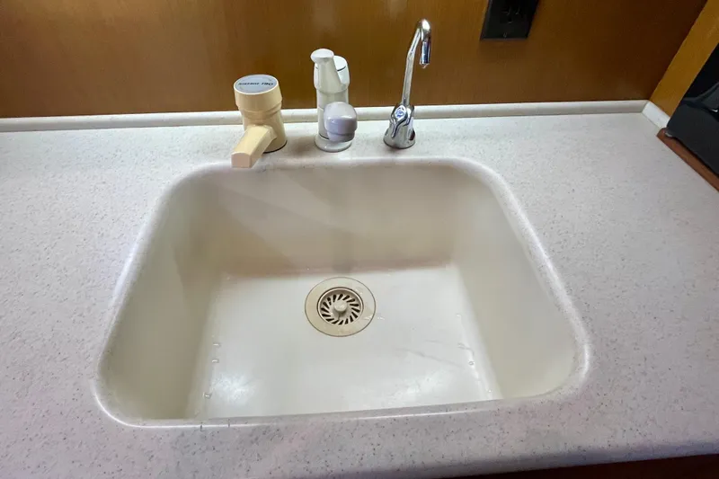 Next Yacht Photos Pics White sink with faucet and soap dispenser on a boat's countertop, Post 42 Convertible, 1999.
