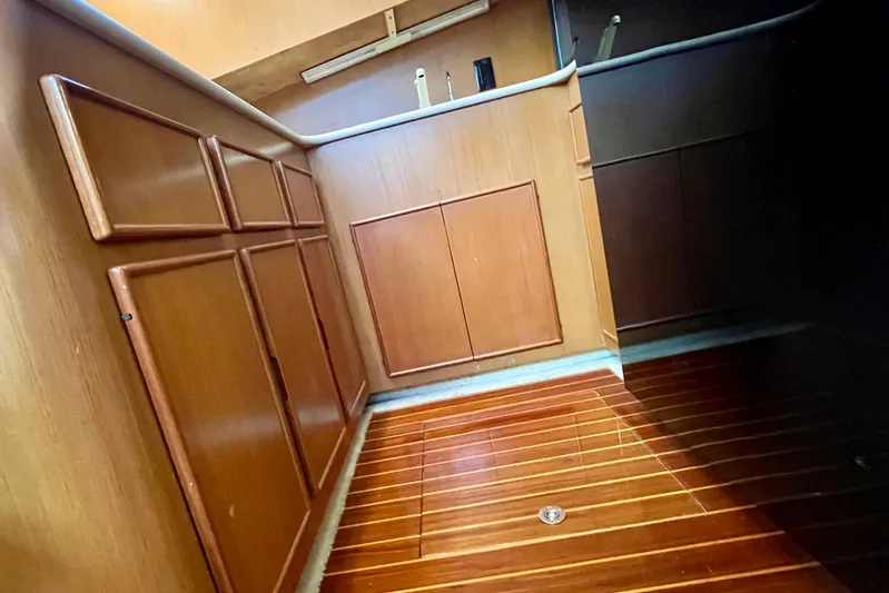 Next Yacht Photos Pics Wooden interior of a 1999 Post 42 Convertible yacht, featuring cabinets and flooring.