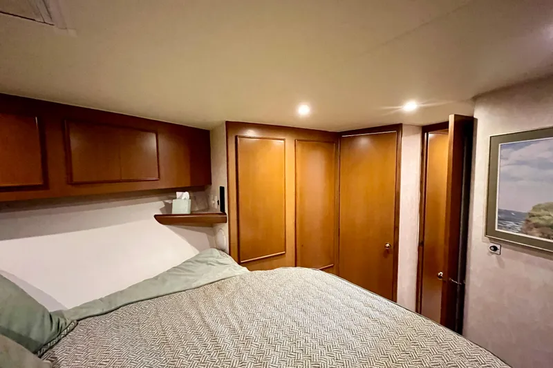 Next Yacht Photos Pics Cozy bedroom in 1999 Post 42 Convertible yacht with wooden cabinets and soft lighting.
