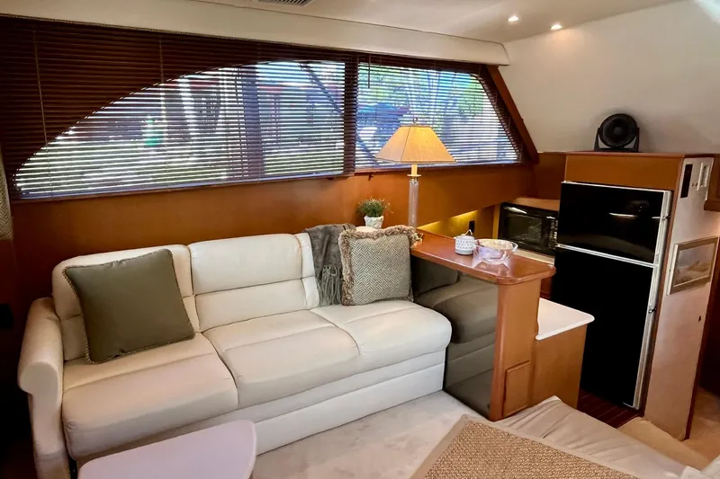 Next Yacht Photos Pics Interior of a 1999 Post 42 Convertible yacht with sofa, lamp, and kitchenette.