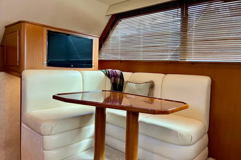 Next Yacht Photos Pics Luxurious interior of 1999 Post 42 Convertible yacht with plush seating and wooden table.