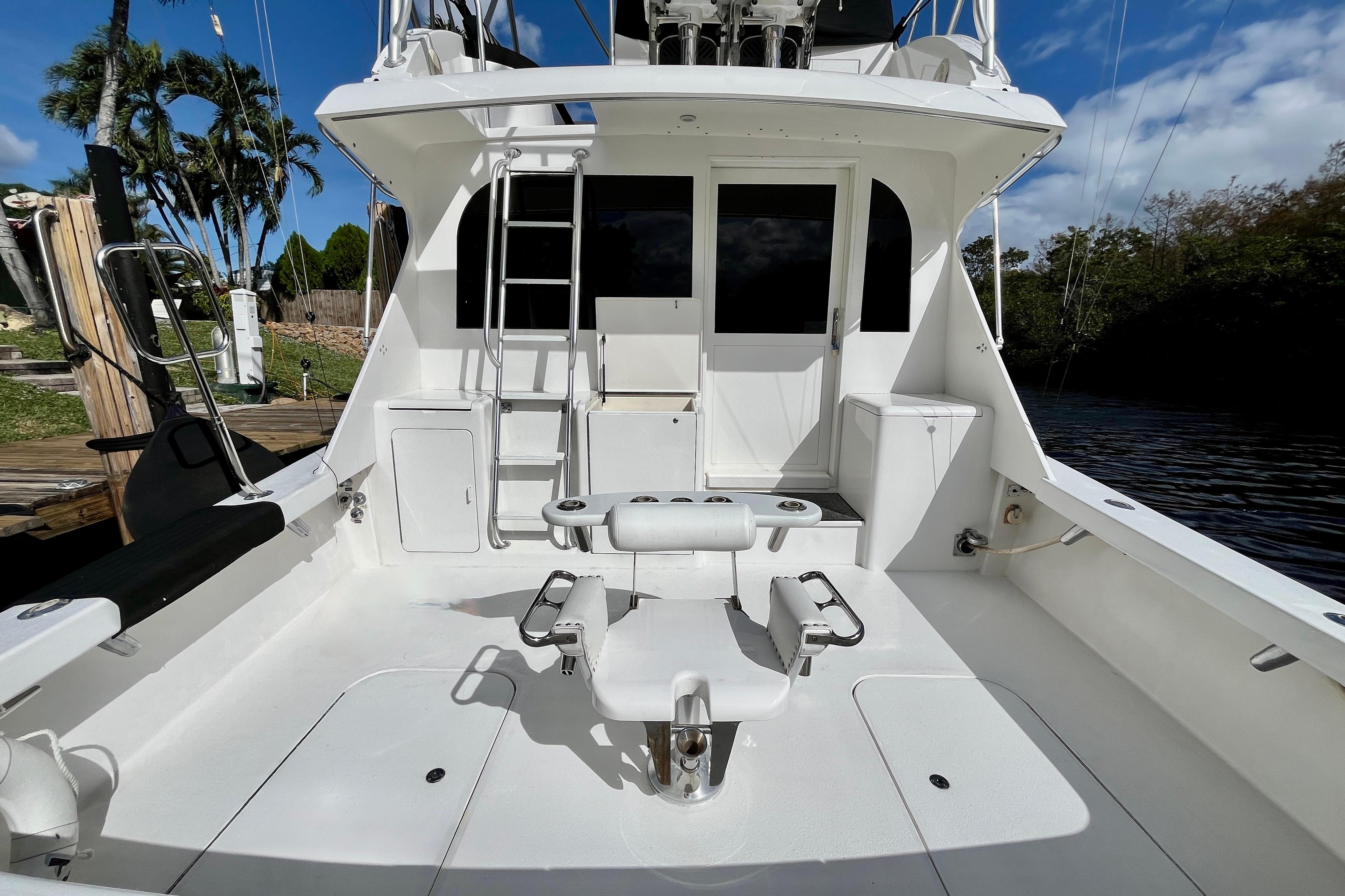 1999 Post 42 Convertible yacht deck with fishing chair and ladder under blue sky.