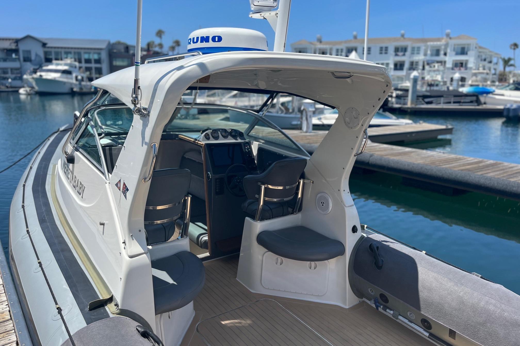 2001 Protector Targa 28 boat docked at marina, showcasing interior seating and controls.