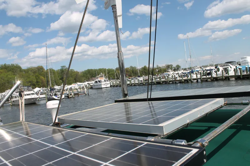 Callisto Yacht Photos Pics Solar panels on a 2009 Outbound 46 sailboat docked at a marina under a blue sky.