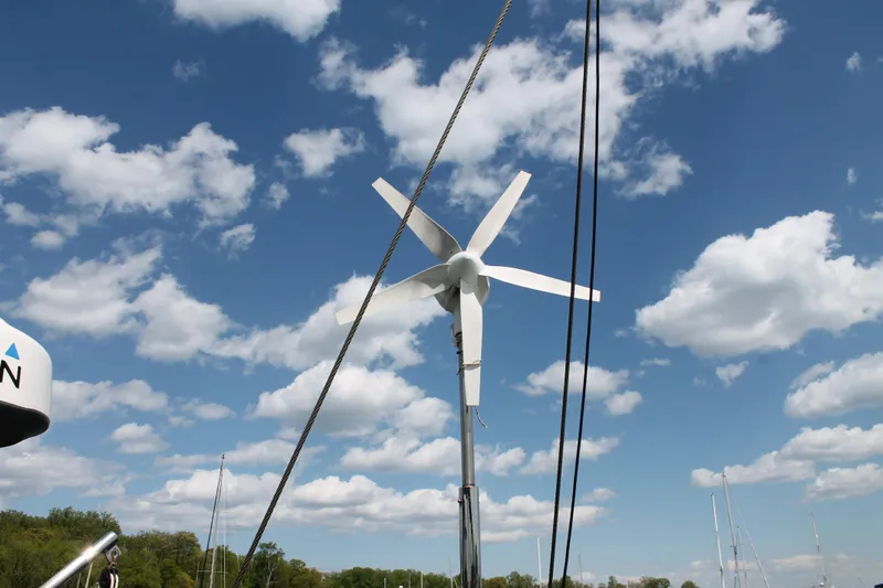 Callisto Yacht Photos Pics Wind turbine on Outbound 46 sailboat, 2009, under a partly cloudy sky.