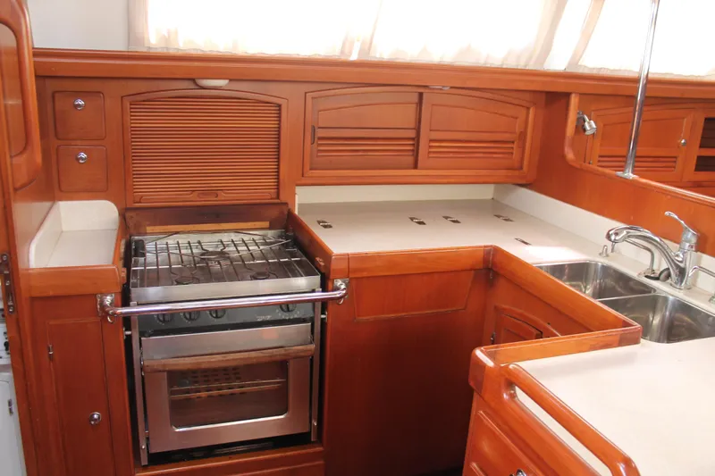 Callisto Yacht Photos Pics Luxurious wooden kitchen interior of 2009 Outbound 46 yacht with stove and sink.