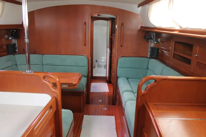 Callisto Yacht Photos Pics Luxurious interior of 2009 Outbound 46 yacht with wooden finish and green seating.