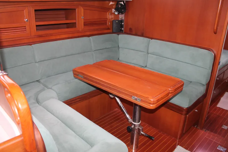Callisto Yacht Photos Pics Luxurious interior of 2009 Outbound 46 yacht with green seating and wooden table.
