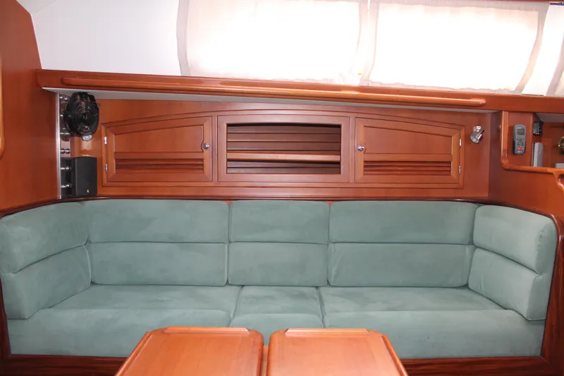 Callisto Yacht Photos Pics Interior of 2009 Outbound 46 yacht with green sofa and wooden cabinetry.
