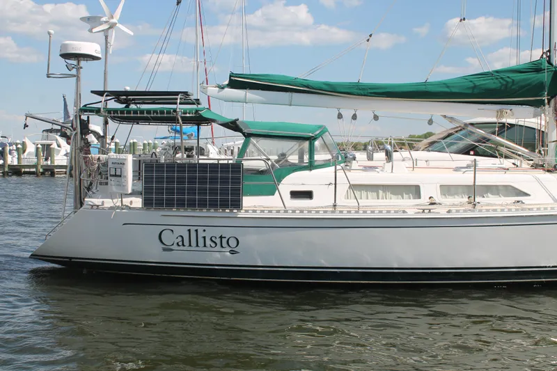 Callisto Yacht Photos Pics Outbound 46 sailboat from 2009 named Callisto, docked with solar panels and green canopy.