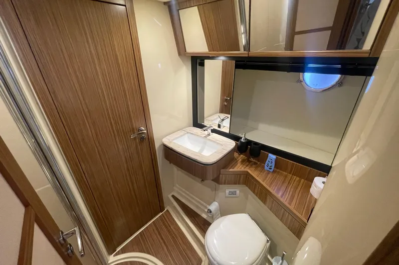 Boa Sorte Yacht Photos Pics Luxurious bathroom in 2017 Azimut Magellano 53 yacht with wood accents and modern fixtures.