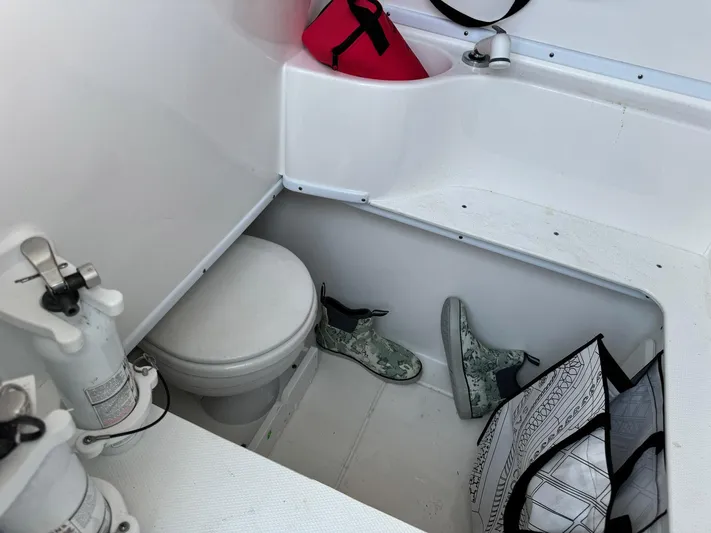  Yacht Photos Pics 2024 Contender 32 ST boat interior with toilet, boots, and storage items.