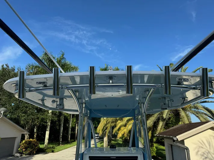  Yacht Photos Pics 2024 Contender 32 ST boat with rod holders, set against a clear blue sky.