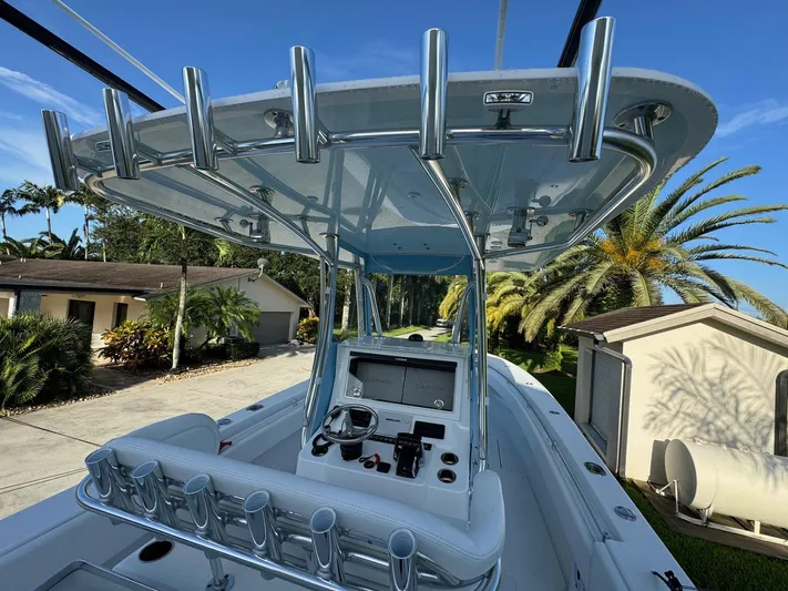  Yacht Photos Pics 2024 Contender 32 ST boat with sleek console and rod holders, set against a tropical backdrop.