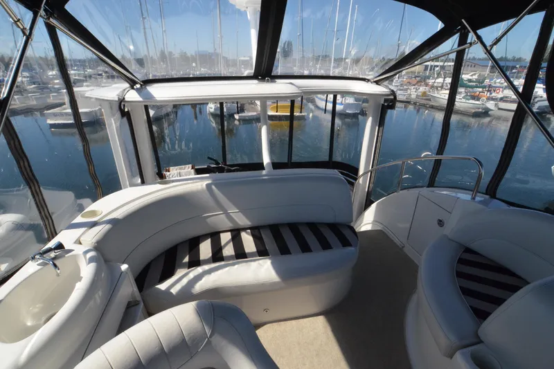 Alta Levica Yacht Photos Pics 2006 Meridian 368 Motoryacht interior with striped seating, overlooking marina through large windows.