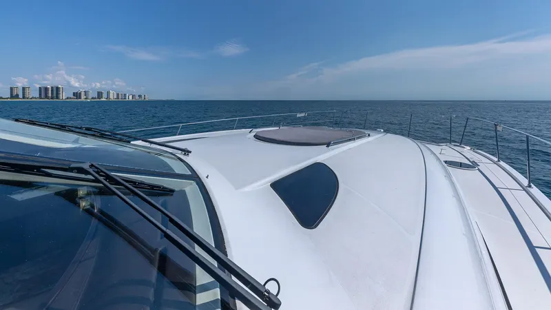  Yacht Photos Pics Custom 650 Catamaran cruising on open sea, city skyline in background, 2010 model.