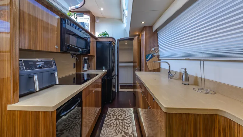  Yacht Photos Pics Luxurious kitchen interior of a 2010 Custom 650 Catamaran with modern appliances and wood finishes.