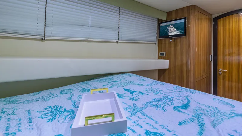  Yacht Photos Pics Luxurious 2010 Custom 650 Catamaran bedroom with nautical-themed bedding and wall-mounted TV.