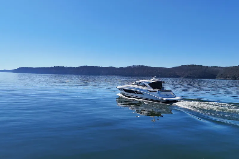  Yacht Photos Pics 2016 Sea Ray Sundancer 510 cruising on a serene lake under a clear blue sky.