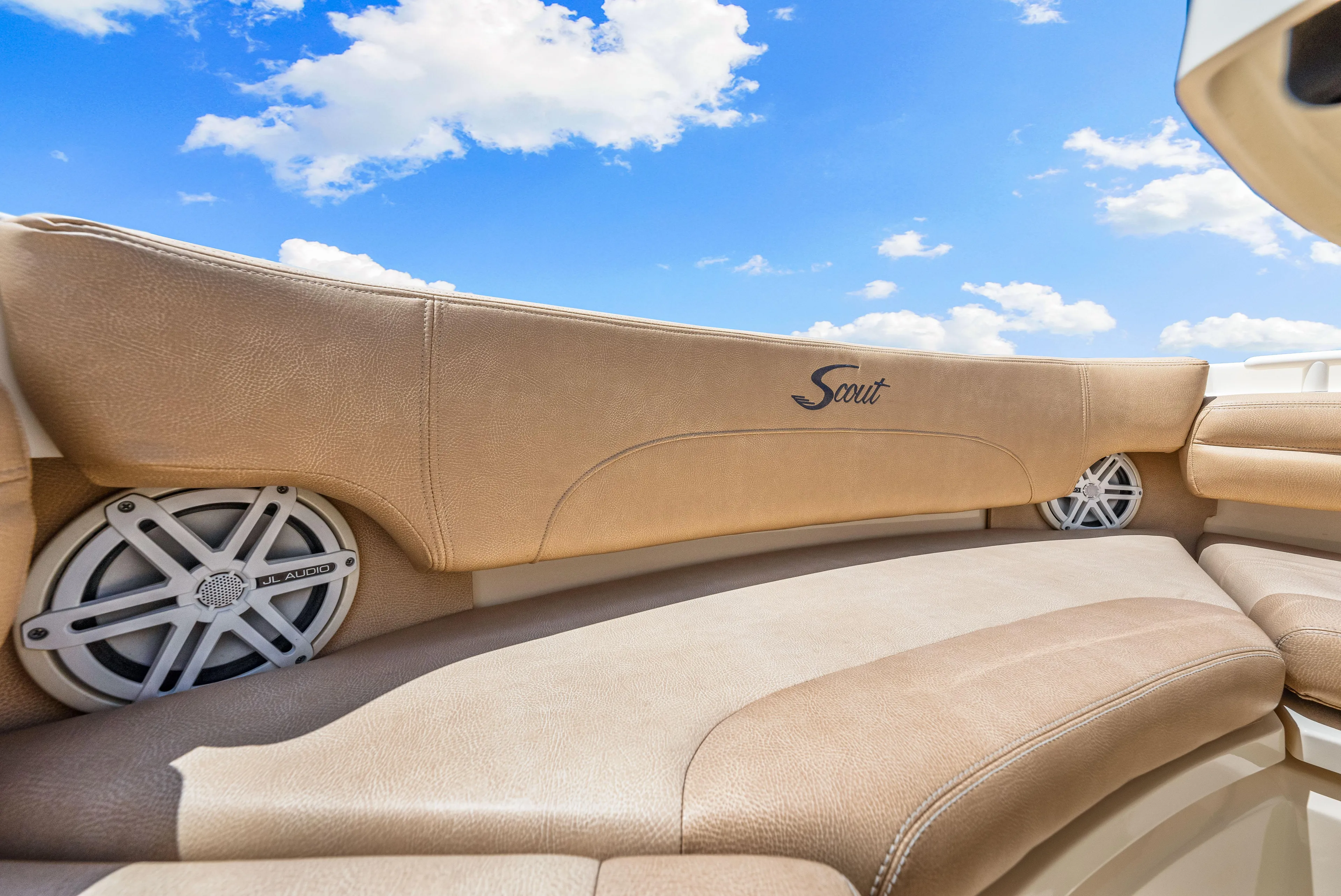 Yacht Photos Pics 2018 Scout 380 LXF boat interior with beige seating and speakers under a blue sky.