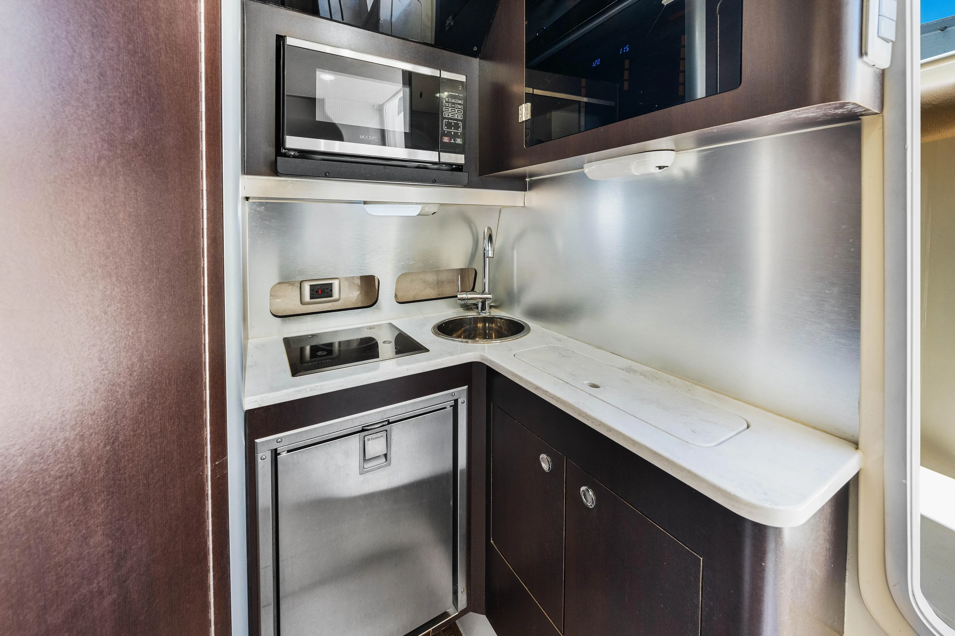  Yacht Photos Pics Compact kitchen area in 2018 Scout 380 LXF boat with microwave, sink, and storage.