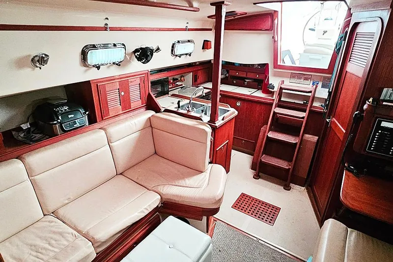  Yacht Photos Pics Interior of 2000 Island Packet 350 sailboat with cozy seating and wooden cabinetry.