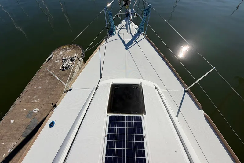 Sea Ranch II Yacht Photos Pics 2018 Jeanneau Sun Odyssey 389 yacht deck with solar panel, docked by calm water.