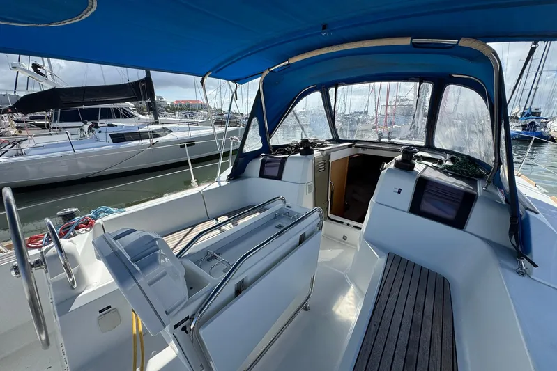 Sea Ranch II Yacht Photos Pics 2018 Jeanneau Sun Odyssey 389 sailboat cockpit with blue canopy, docked at marina.