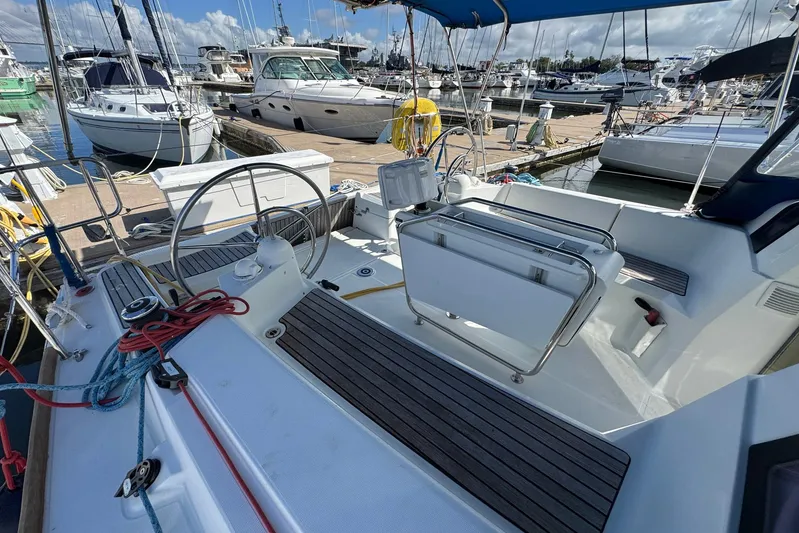 Sea Ranch II Yacht Photos Pics 2018 Jeanneau Sun Odyssey 389 sailboat cockpit at marina, featuring steering wheel and seating.
