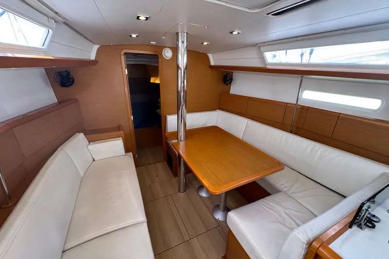 Sea Ranch II Yacht Photos Pics Interior of 2018 Jeanneau Sun Odyssey 389 sailboat with cozy seating and wooden table.