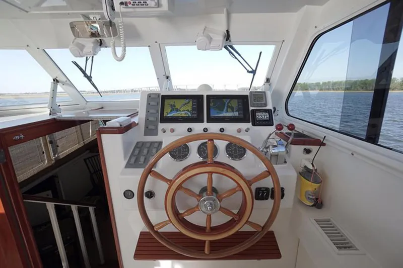 Faith Yacht Photos Pics Helm of 2003 Huckins 44 Atlantic yacht with wooden steering wheel and navigation equipment.
