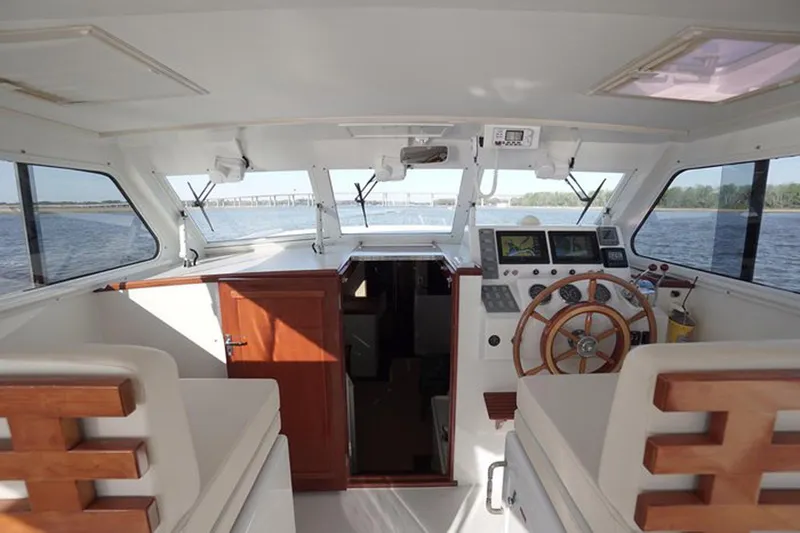 Faith Yacht Photos Pics Interior view of 2003 Huckins 44 Atlantic yacht with wooden steering wheel and navigation equipment.