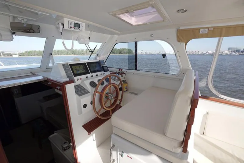 Faith Yacht Photos Pics Interior of 2003 Huckins 44 Atlantic yacht with steering wheel and navigation equipment.