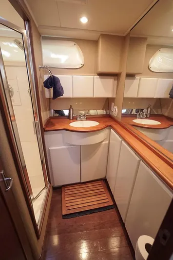 Faith Yacht Photos Pics Luxurious bathroom in 2003 Huckins 44 Atlantic yacht with wood accents and modern fixtures.