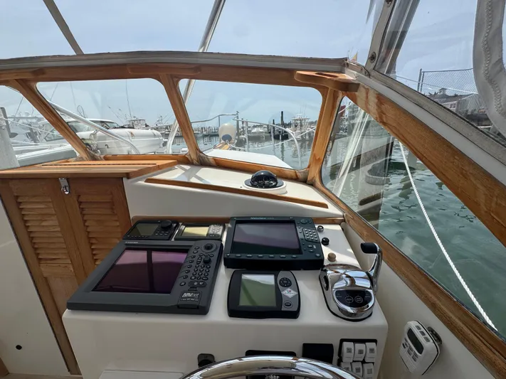 Wrecking Crew Yacht Photos Pics Helm of 2006 Fortier 26 boat with navigation equipment and wooden accents.