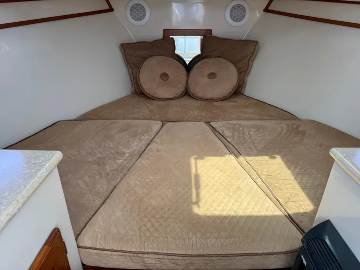 Wrecking Crew Yacht Photos Pics Interior cabin of a 2006 Fortier 26 boat with beige cushions and pillows.