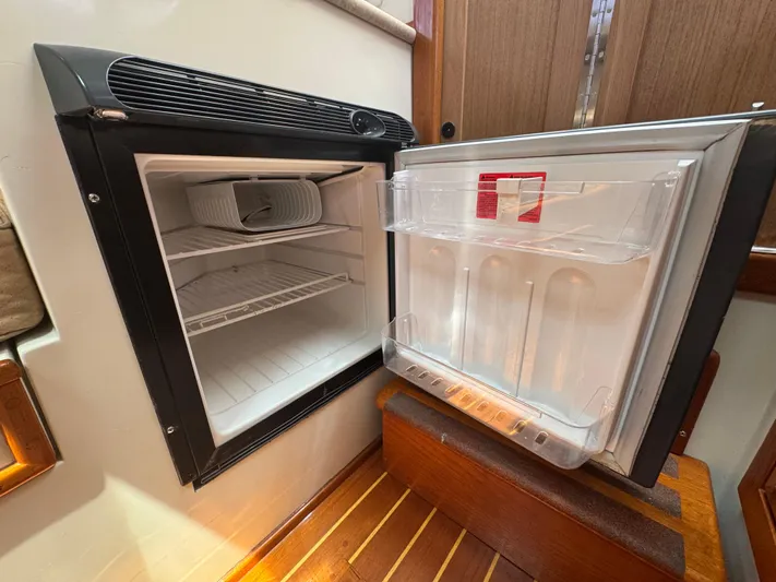 Wrecking Crew Yacht Photos Pics Open refrigerator inside a 2006 Fortier 26 boat, showing empty shelves and door storage.