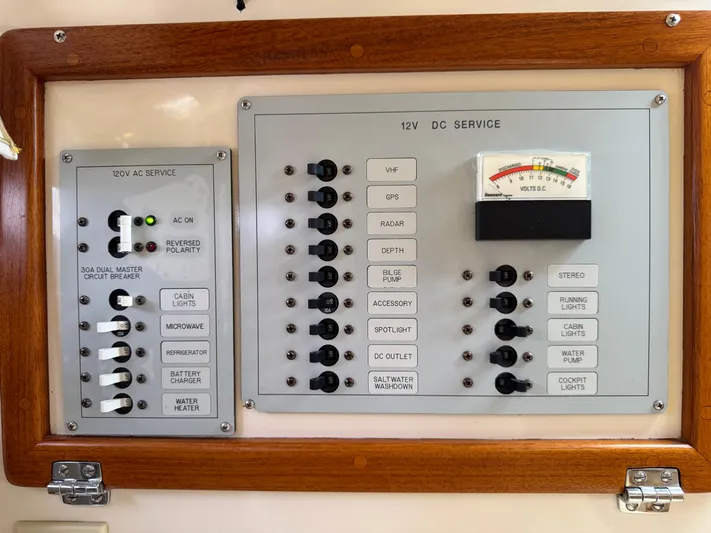 Wrecking Crew Yacht Photos Pics Electrical control panel on a 2006 Fortier 26 boat, featuring AC and DC service switches.