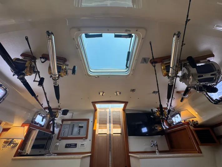 Wrecking Crew Yacht Photos Pics Interior of 2006 Fortier 26 boat with fishing rods and skylight.