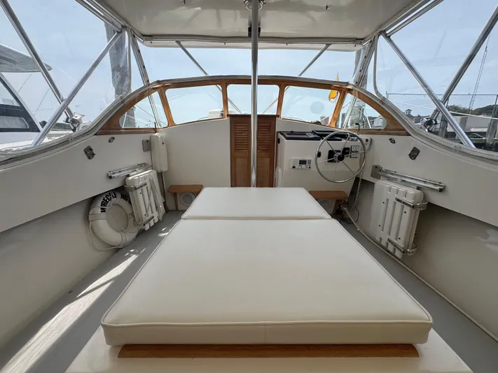 Wrecking Crew Yacht Photos Pics Interior of a 2006 Fortier 26 boat with cushioned seating and steering wheel.