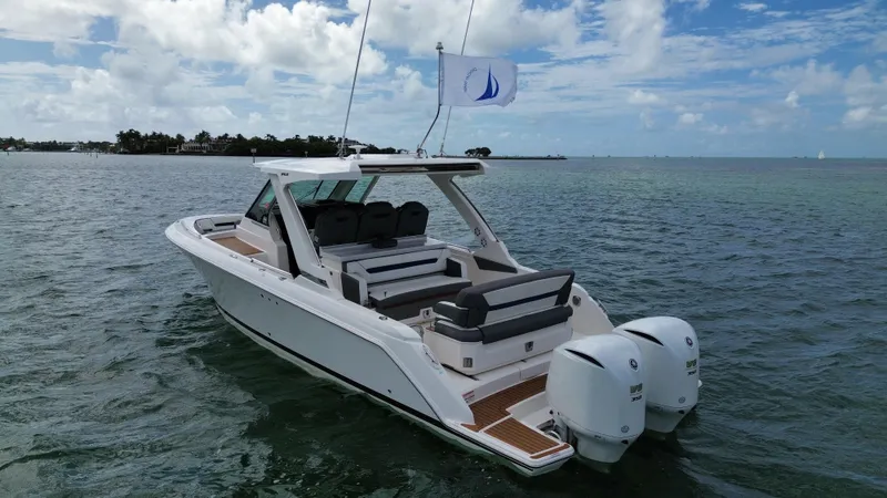  Yacht Photos Pics 2021 Tiara Sport 34 LS boat on calm water under a partly cloudy sky.