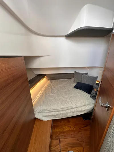  Yacht Photos Pics 2021 Tiara Sport 34 LS cabin interior with cozy bed and wooden accents.