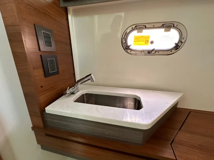  Yacht Photos Pics 2021 Tiara Sport 34 LS yacht interior with modern sink and porthole window.