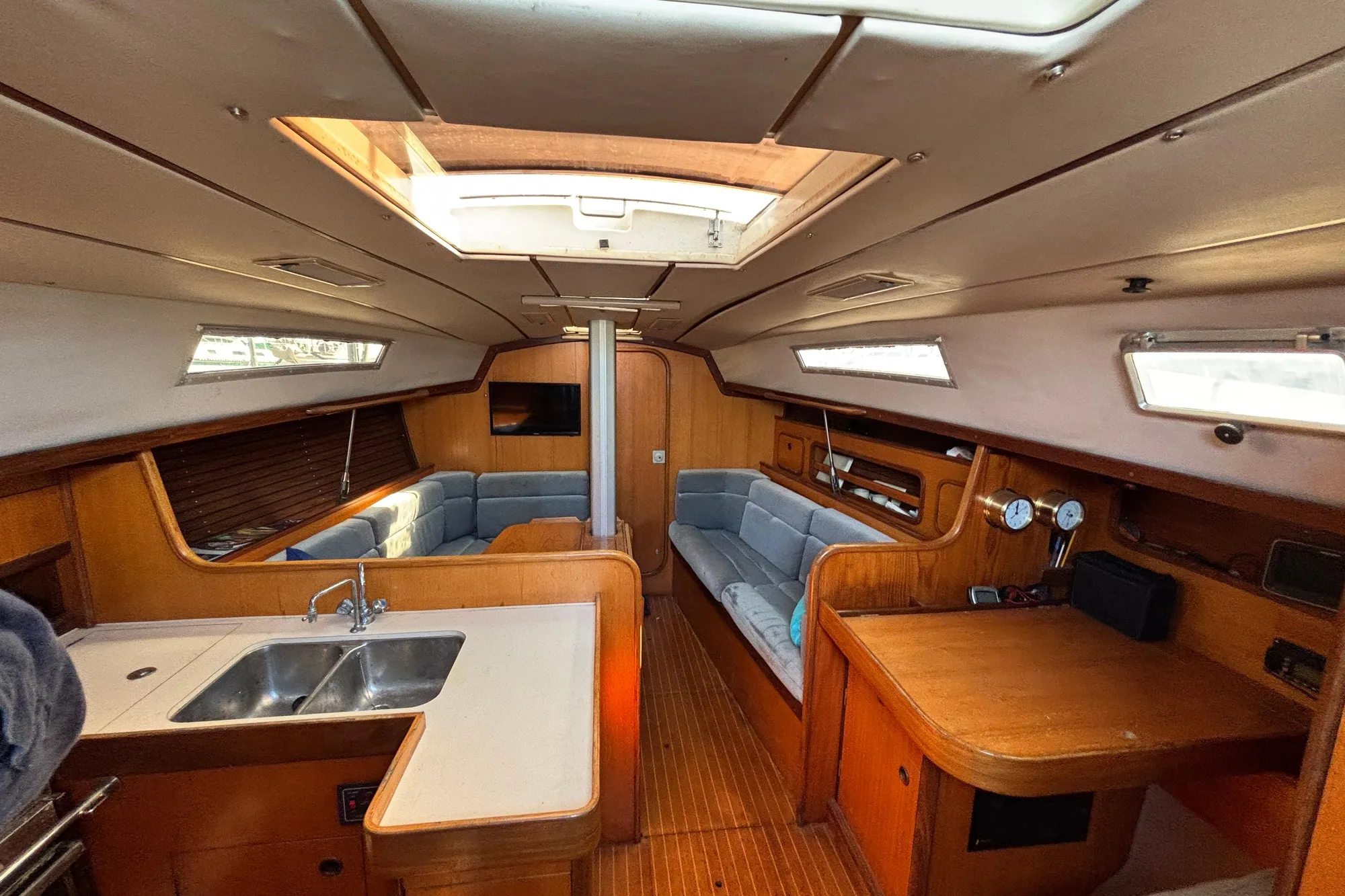Interior of 1986 Beneteau First 375 sailboat with wood finish and cozy seating area.