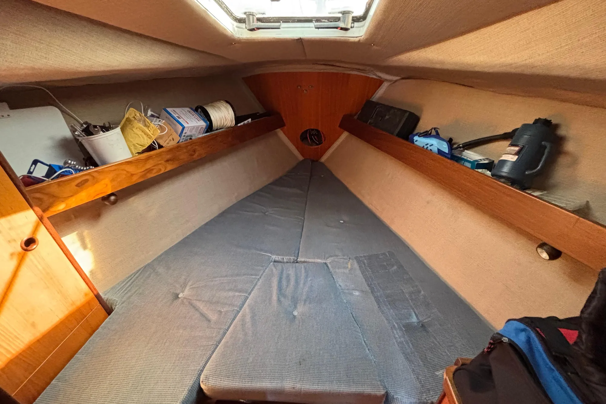 Interior cabin of 1986 Beneteau First 375 sailboat with storage and bedding.