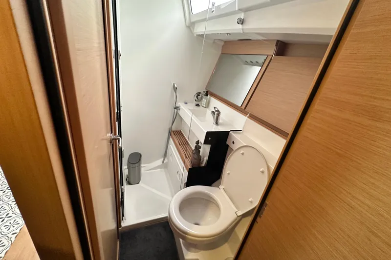 Lost Traveler Yacht Photos Pics Modern bathroom in 2020 Jeanneau Sun Odyssey 440 yacht, featuring sleek design and compact amenities.