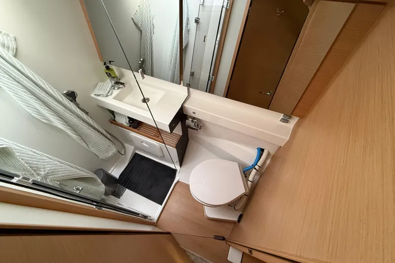 Lost Traveler Yacht Photos Pics Bathroom interior of 2020 Jeanneau Sun Odyssey 440 yacht, featuring modern fixtures and wood accents.