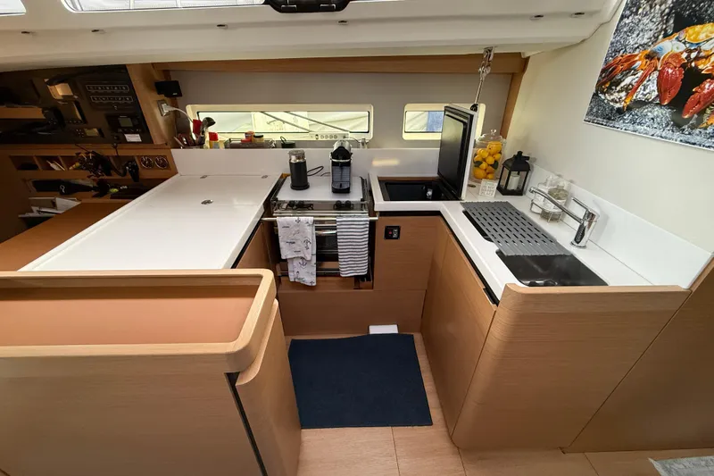 Lost Traveler Yacht Photos Pics Modern kitchen interior of 2020 Jeanneau Sun Odyssey 440 yacht, featuring sleek design and appliances.