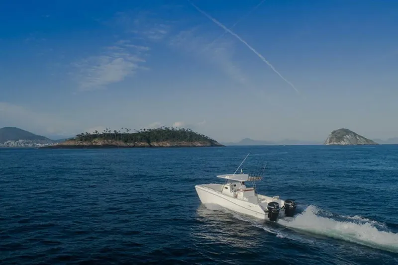  Yacht Photos Pics 2025 Garnet Offshore 300 HT boat cruising near scenic islands under clear blue sky.