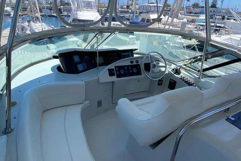 Dianne Yacht Photos Pics 2003 Bluewater Yachts 6000 custom series helm with white seating and control panel.